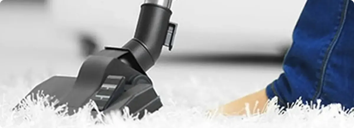 Close-up of a professional vacuuming a white carpet in Litchfield.
